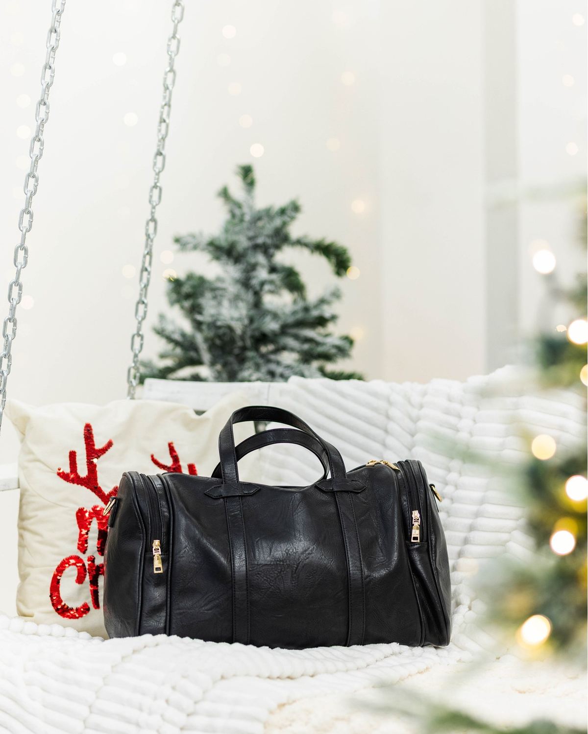 The Ruth, a black vegan-leather travel duffle bag by The Bag Depot with a trolley sleeve.
