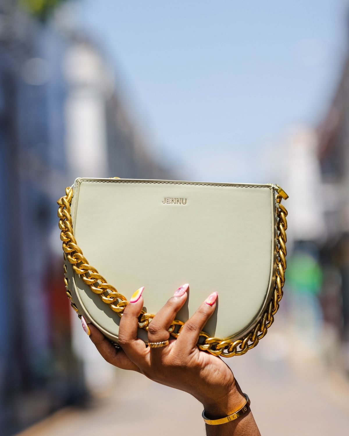 The Zohra, a sage green structured handbag with a chunky gold chain strap by The Bag Depot.