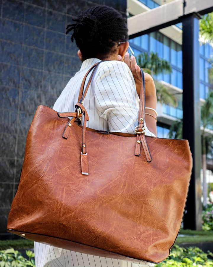 Woman carrying The Bag Depot's tan Iris tote bag over her shoulder, with its removable pouch tucked inside.
